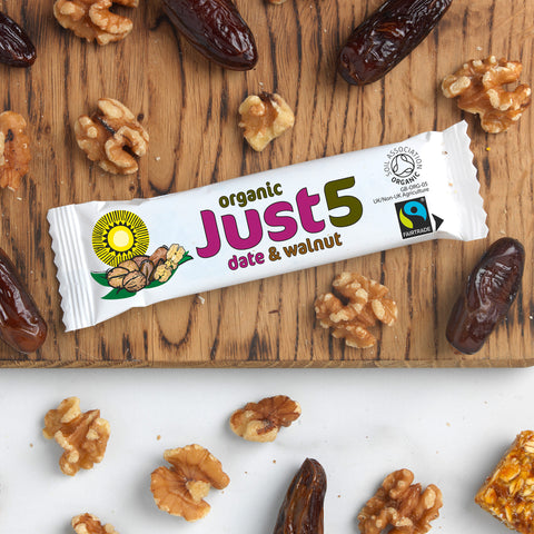 front of organic Just 5 date and walnut bar on table top with dates and walnut pieces scattered