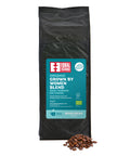 front of Organic Grown by Women Blend 1kg coffee bag with pile of roasted beans