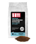 front of Organic Colombian Excelso medium roast coffee bag with pile of ground coffee