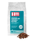 front of Organic Grown by Women Blend coffee bag with pile of roasted beans