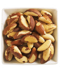 white square bowl filled with whole brazil nuts